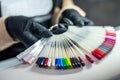 woman working in a nail salon offers a color of nail polish to one of her clients and smiles. Royalty Free Stock Photo