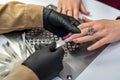 woman working in a nail salon offers a color of nail polish to one of her clients and smiles. Royalty Free Stock Photo