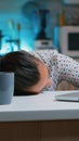 Woman working at night falling asleep on desk Royalty Free Stock Photo