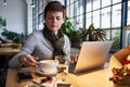 Woman working on a notebook and drinking coffee in a cafe