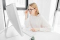 Woman working in office, sitting at desk, using computer and looking on screen Royalty Free Stock Photo