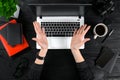 Woman working at the office table. Top view of human hands, laptop keyboard, a cup of coffee, smartphone, notebook and a Royalty Free Stock Photo