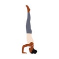 Woman working out against white wall, doing yoga or pilates exercise. Headstand, salamba sirsasana II