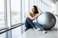 Woman working out with exercise ball in gym. Pilates woman doing exercises in the gym workout room with fitness ball. Fitness woma