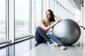 Woman working out with exercise ball in gym. Pilates woman doing exercises in the gym workout room with fitness ball. Fitness woma