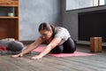 Woman working out indoors, doing variation of twisted forward bend yoga exercise Royalty Free Stock Photo