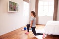 Woman Working Out To Fitness DVD On TV In Bedroom