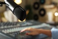 Woman working with professional mixing console in modern radio studio, focus on microphone. Space for text Royalty Free Stock Photo