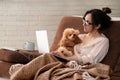 The woman is working remotely. Women with the dog working using a laptop at home. Royalty Free Stock Photo