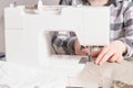 woman working with sewing machine, white sewing machine on the table, sewing materials tailoring process Royalty Free Stock Photo