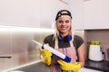 Woman working with silicone glue. Caulking the kitchen