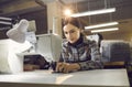 Woman working at table with industrial sewing machine at shoe or clothing factory Royalty Free Stock Photo