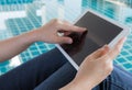 Woman working with tablet sitting at swimming pool Royalty Free Stock Photo