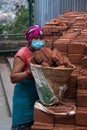 Woman working to stack bricks into a basket