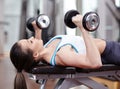 Woman working triceps and chest with dumbbells