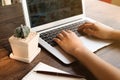 A woman is working by using a laptop computer on table. Hands ty Royalty Free Stock Photo