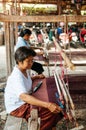 Woman working on Vintage Thai style wooden weaving loom with silk fiber