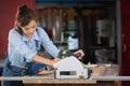 Woman works in a carpentry shop. Carpenter working on woodworking machines in carpentry shop Royalty Free Stock Photo
