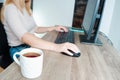 A woman works on a computer from home. Cropped image of businesswoman using computer while having tea at desk Remote work.. Royalty Free Stock Photo