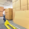 Woman works with forklift truck in a warehouse with cartons Royalty Free Stock Photo