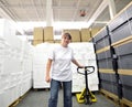 Woman works with forklift truck in a warehouse with cartons Royalty Free Stock Photo