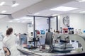 Woman works in the laboratory with microscope. View from back