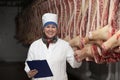 A woman works at a meat processing plant