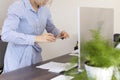 A woman works in the office, holds a phone in her hands and photographs documents.