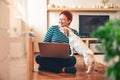 Woman works online using laptop computer, dog interferes. Quarantine coronavirus Royalty Free Stock Photo