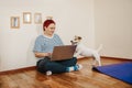 Woman works online using laptop computer, dog interferes. Quarantine coronavirus