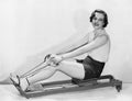 Woman works out on rowing machine Royalty Free Stock Photo