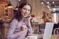 Woman works remotely online from cafe while quarantine coronavirus is in effect. Concept of checking mail, blogger, freelancer