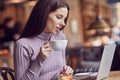 Woman works remotely online from cafe while quarantine coronavirus is in effect. Concept of checking mail, blogger, freelancer Royalty Free Stock Photo