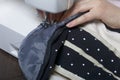 A woman works on a sewing machine. Repair of backpack.