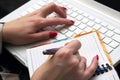 Woman works on a white laptop.