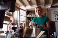 Woman In Workshop Choosing Paintbrush For Upcycling And Craft Projects