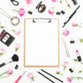 Woman workspace with cosmetics clipboard, accessories and pink roses on white background. Top view. Flat lay. Beauty blog backgrou Royalty Free Stock Photo