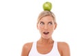 Woman, wow and apple on head in studio for wellness, diet and balance by white background. Isolated model, fruit and