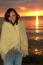 Woman wrapped in blanket at sunset