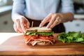 a woman wrapping a blt sandwich for lunch