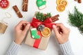 Woman wrapping Christmas gift at white wooden table Royalty Free Stock Photo