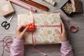 Woman wrapping Christmas gift at white wooden table, top view Royalty Free Stock Photo