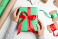 Woman wrapping Christmas gift at white wooden table Royalty Free Stock Photo