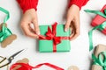 Woman wrapping Christmas gift at white wooden table