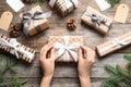 Woman wrapping Christmas gift at wooden table Royalty Free Stock Photo