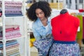 woman wrapping floral material around mannequin