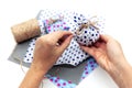 Woman is wrapping a gift with natural materials and organic cotton