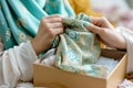 woman wrapping a new hijab in a gift box