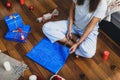 Woman wraps Christmas gifts sitting at home on floor