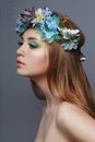 Woman with a wreath of blue flowers on her head. Beautiful makeup and flowers, natural clean skin, care and hydration. Natural